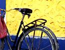 Bicycle leaning against a blue and yellow wall